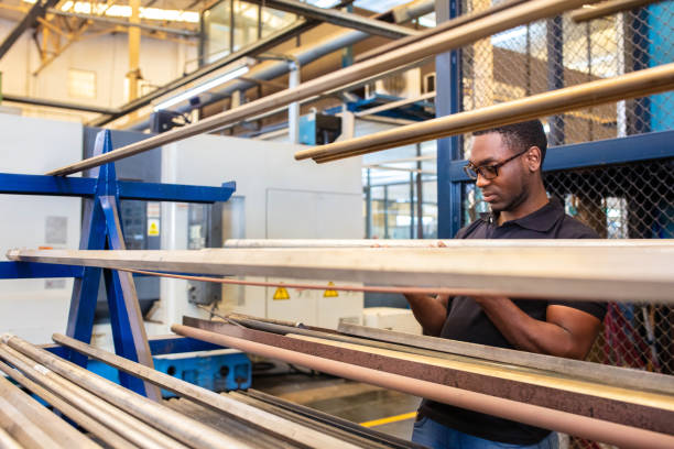 trabalhador inspecionando a matéria-prima na fábrica - african descent factory accuracy analyzing - fotografias e filmes do acervo