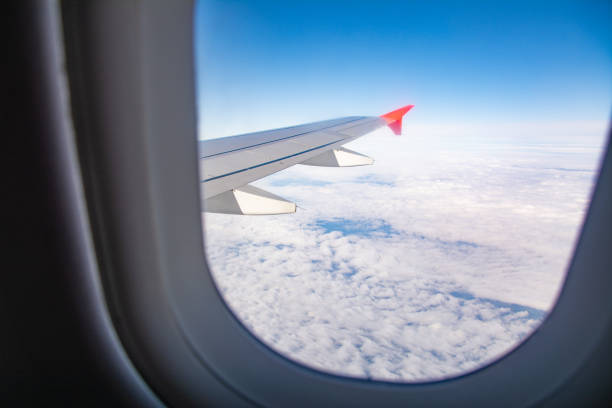 istock Airplane wing and clouds are visible from the porthole 1219929707