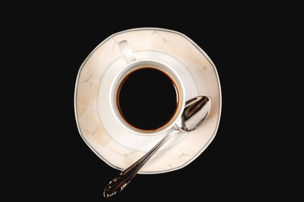 istock Filled light-pink cup of black coffee with spoon, vertical view 1219929929