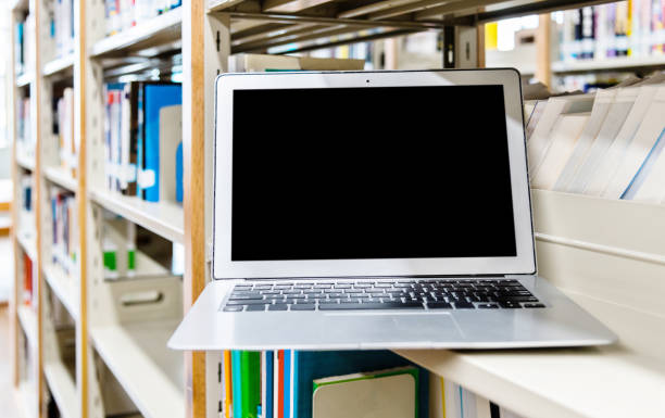 istock Blank laptop on the bookshelf of library 1219931239