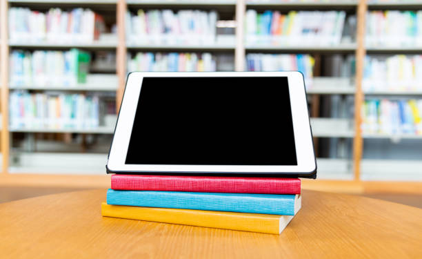 istock Digital tablet and books on wooden table 1219931606