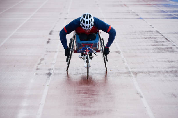 atleta masculino con discapacidad física que viene hacia el final mientras corre - physical impairment athlete sports race wheelchair fotografías e imágenes de stock