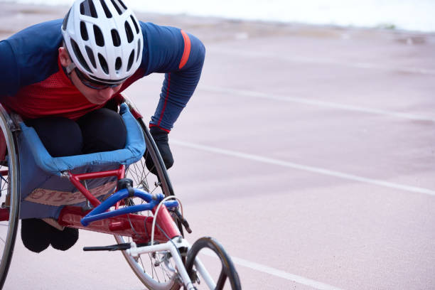 determinado atleta masculino discapacitado en carreras de casco en ciclo de mano especializado - physical impairment athlete sports race wheelchair fotografías e imágenes de stock