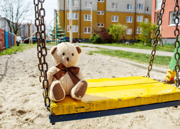 istock forgotten toy teddy bear in the empty quarantined playground 1219933215