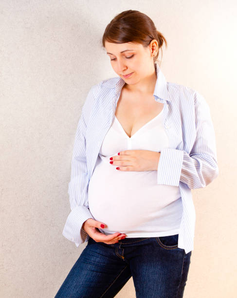 istock Pregnant woman touching belly gently 1219934563