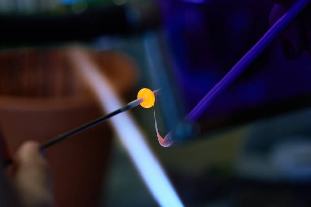 istock Glass stick workpiece held by lampworking master during burning and melting 1219934684