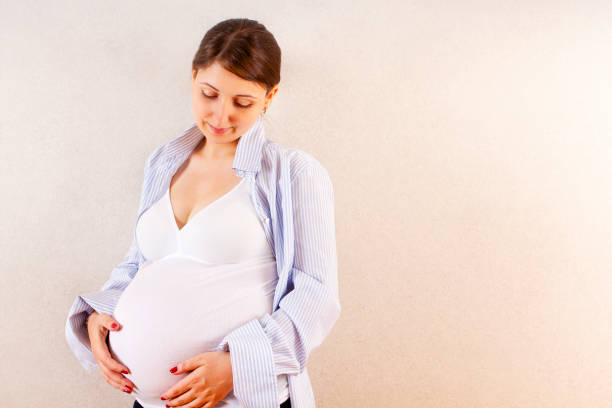 istock Pregnant woman touching belly gently 1219935023