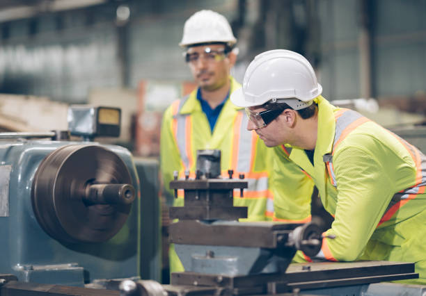 istock technician and Apprentice discussion to metal component at machine in factory 1219935741