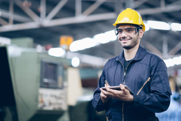 istock Smile technician engineer standing and checking process on tablet in factory 1219936296