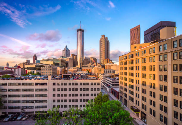 Skyline view of Downtown and Midtown Atlanta at golden hour, with sunlight illuminating the buildings and parking decks.
