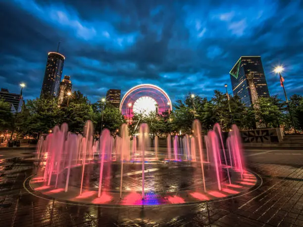 Long exposure of the water fountains in Centennial Olympic Park in Downtown Atlanta, Georgia with the city skyline and Ferris wheel in the background