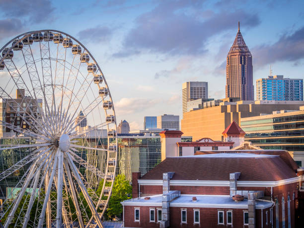 Atlanta Skyline with Ferris Wheel View of Atlanta, Georgia on a beautiful spring day with sunlight reflecting off the Ferris wheel in Downtown. ferris wheel photos stock pictures, royalty-free photos & images