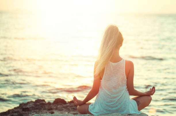 istock young woman doing yoga on the beach 1219939174