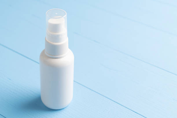 istock Antiseptic spray in a white plastic container on a blue wooden background 1219940489