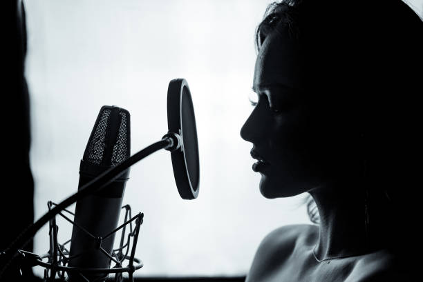 jeune femme avec le microphone dans le studio d’enregistrement. - arts or entertainment audio photos et images de collection