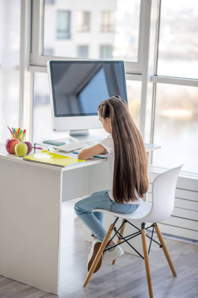 istock Long-haired teen sitting at the table and studying 1219940975