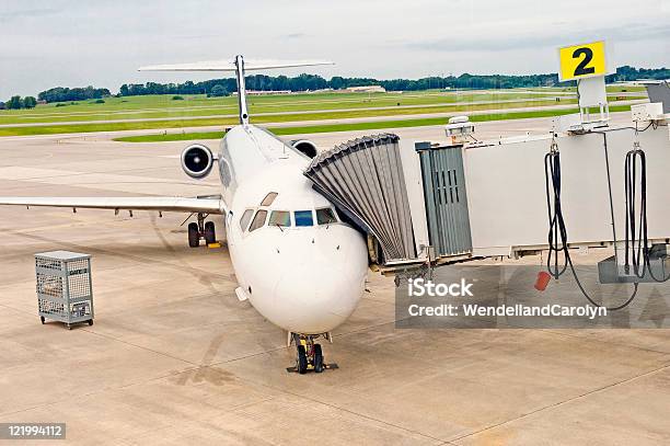 Avión De Carga O Descarga De Pasajeros Foto de stock y más banco de imágenes de Aeropuerto - Aeropuerto, Ala de avión, Aparcamiento