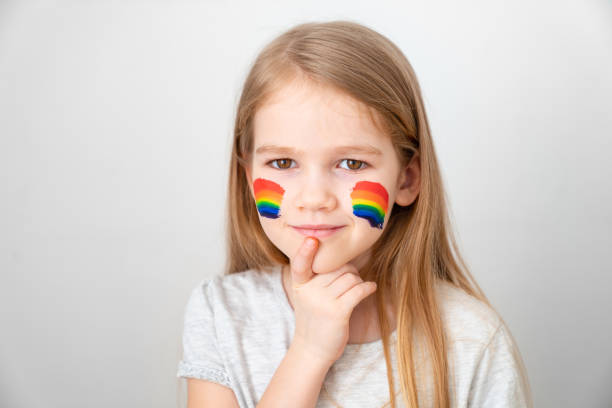 istock child girl painted cheeks a rainbow. stay home. 1219941335