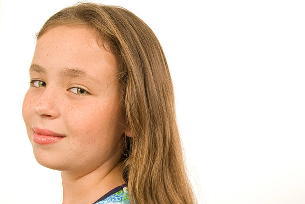 close-up of a beautiful little girl in a colorful dress lying on the grass looking at the camera with a white background and copy space