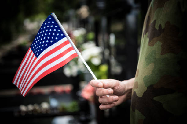 soldato in piedi al cimitero- coronavirus - depression sadness usa american flag foto e immagini stock