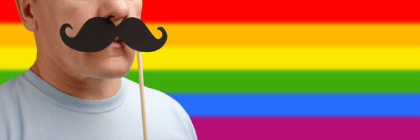 retrato hombre caucásico con bigote falso en el palo en apoyo de un orgullo gay para ayudar a las personas a concienciar los derechos lgbt. - lesbian gay man rainbow multi colored fotografías e imágenes de stock