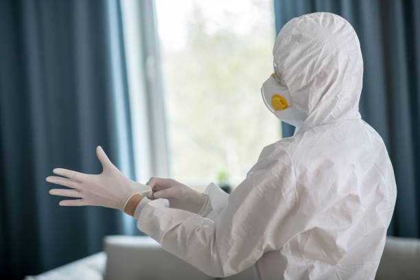istock Woman in white workwear wearing protective gloves 1219945299