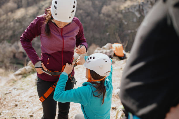 istock Instructor checking climbing harness before letting her climb group goes sport climbing 1219946529