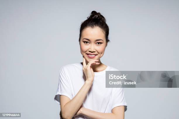 Cheerful Asian Young Woman Stock Photo - Download Image Now - Gray Background, Smiling, 20-24 Years