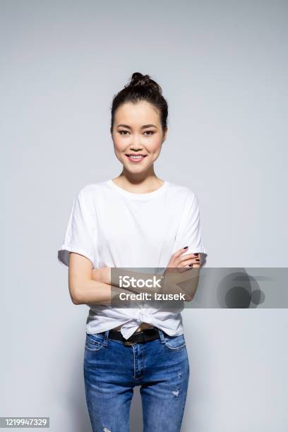 Friendly Asian Young Woman Standing With Arms Crossed Stock Photo - Download Image Now
