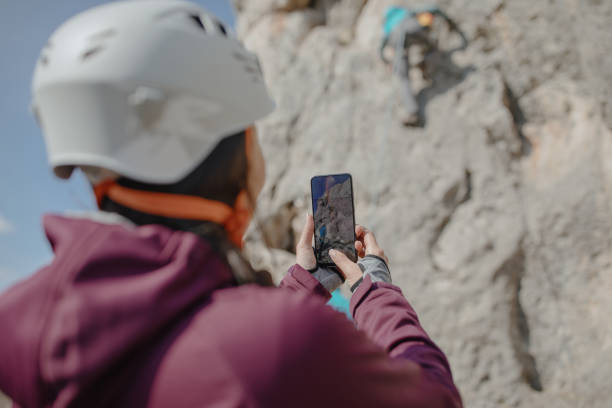 mujer tomando fotos de su amigo escalada en roca - rock climbing fotos fotografías e imágenes de stock