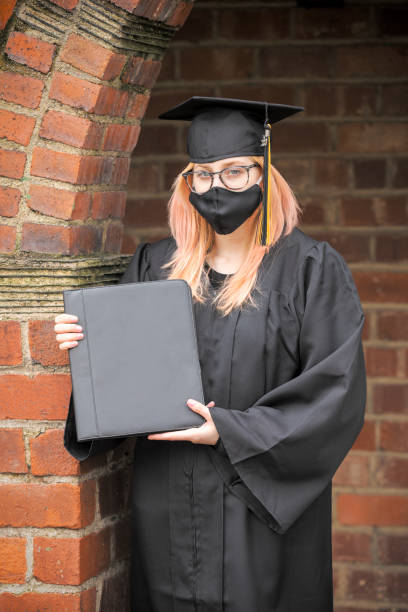 istock 2020 Graduate in Matching Face Mask with Diploma 1219948712