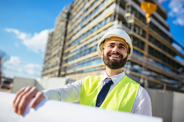istock Handsome mid adult architect holding blueprint and smiling 1219952045