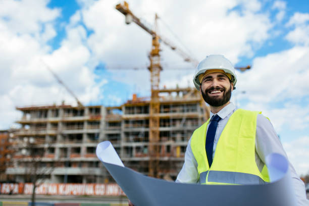 istock Handsome mid adult architect standing on construction site and smiling 1219952107