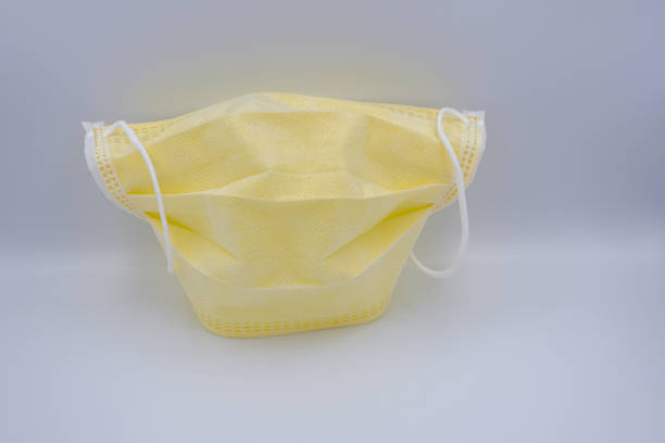 istock Yellow medical mask isolated on white background 1219952459