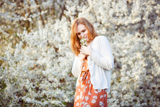 istock woman in flowering bush with branches in  hands 1219952470
