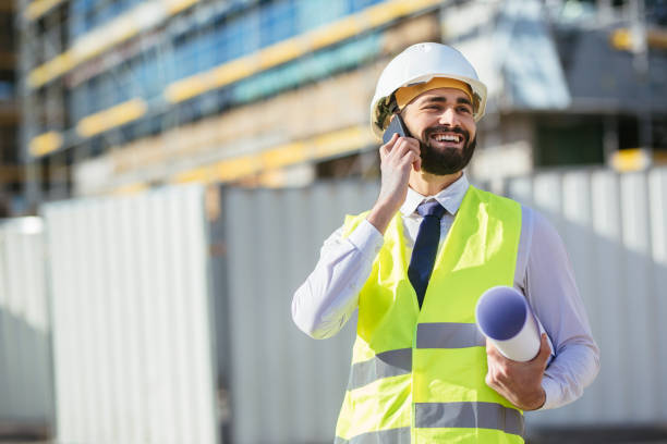 istock Mid adult engineer holding blueprint and talking on mobile phone 1219952724