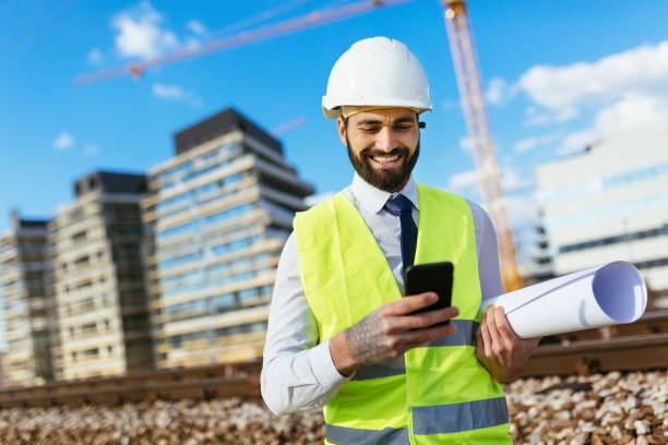 istock Portrait of mid adult engineer text messaging on construction site 1219954161