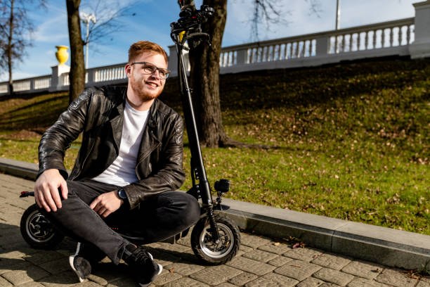 istock Successful man with technological eco-friendly electric kick scooter. Concept with copy space at the street in a city 1219954976