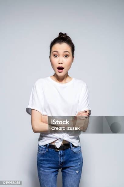 Surprised Young Woman Staring At Camera With Arms Crossed Stock Photo - Download Image Now