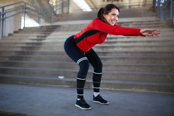 屋外でスクワットエクササイズをしているフィットスポーツウーマン - running track women running spring ストックフォトと画像