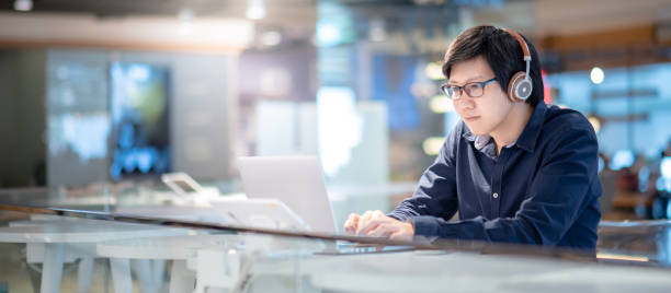 istock Asian man listening to music using laptop computer 1219960647