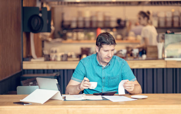 Accountant looking worried over the profit and loss accountancy papers stock photo