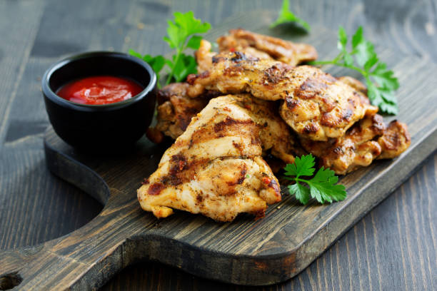 istock Grilled chicken fillet with tomato sauce and greens. 1219963306