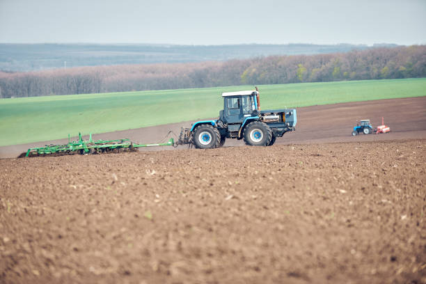 istock A tractor plowing and sowing in the field 1219963430