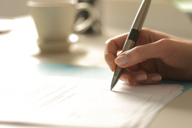 istock Woman hands signing contract at night 1219963431