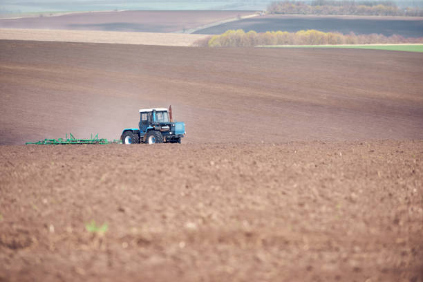 istock A tractor plowing and sowing in the field 1219963432