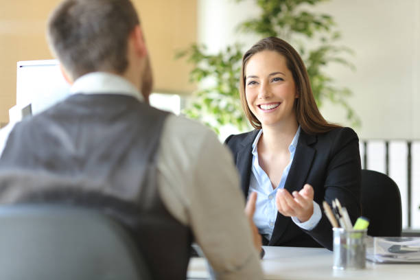 happy executive coworkers laughing and talking at the office - desk meeting conference business imagens e fotografias de stock