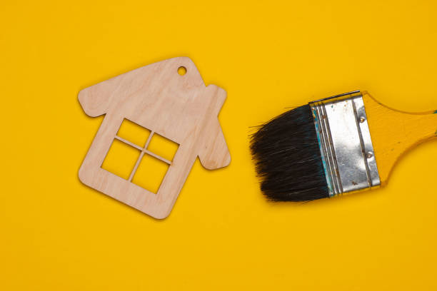 istock Mini house figurine, brush on a yellow background. Top view 1219964018