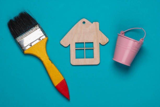 istock Mini house figurine, brush, bucket on a blue background. Top view 1219964023