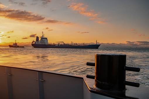 Silhouette of ships at sunset in the Black Sea and their reflection in the sea